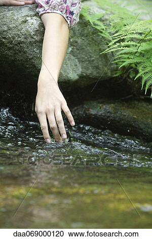 Young woman's hand touching water in stream View Large Photo Image Stock Image - Young woman's hand touching water in stream. Fotosearch