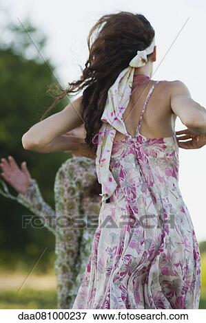Stock Photo - Young women running outdoors, rear view. Fotosearch