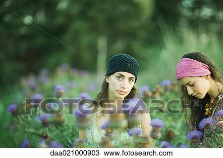 Young women standing in field of thistle View Large Photo Image Stock Image - Young women standing in field of thistle. Fotosearch