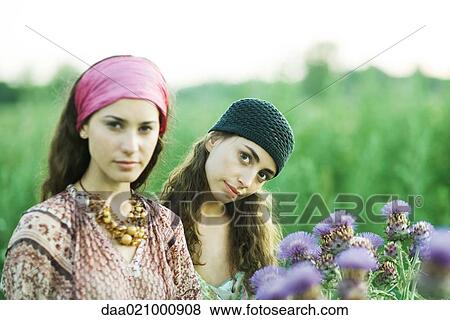 Young women standing in field, thistle in foreground View Large Photo Image Stock Photo - Young women standing in field, thistle in foreground. Fotosearch