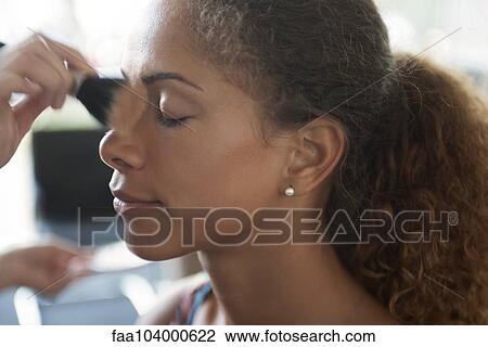 Stock Image - Applying face powder. Fotosearch