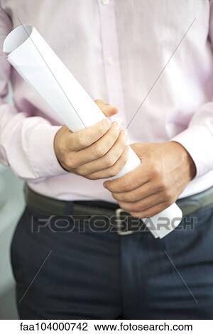 Architect holding rolled up blueprint View Large Photo Image Stock Image - Architect holding rolled up blueprint. Fotosearch