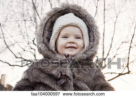 Baby girl wearing fur coat outdoors, portrait View Large Photo Image Stock Photo - Baby girl wearing fur coat outdoors, portrait. Fotosearch