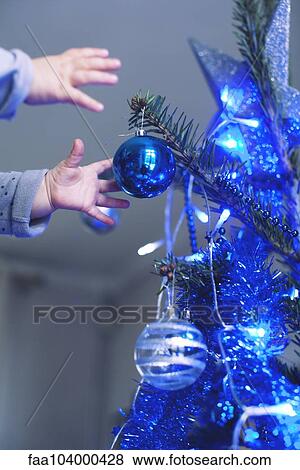 Stock Photo - Baby reaching for Christmas tree ornament. Fotosearch