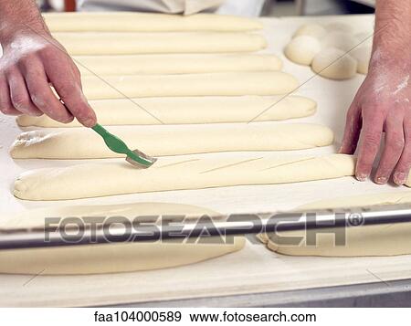 Baker scoring bread dough, cropped View Large Photo Image Stock Photo - Baker scoring bread dough, cropped. Fotosearch
