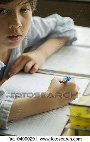 Stock Image - Boy distracted from doing homework. Fotosearch