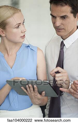 Business associates using digital tablet together View Large Photo Image Stock Image - Business associates using digital tablet together. Fotosearch