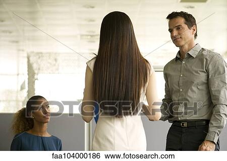 Stock Photograph - Business colleagues meeting in office waiting room. Fotosearch