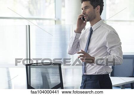 Businessman at office using cell phone View Large Photo Image Stock Image - Businessman at office using cell phone. Fotosearch