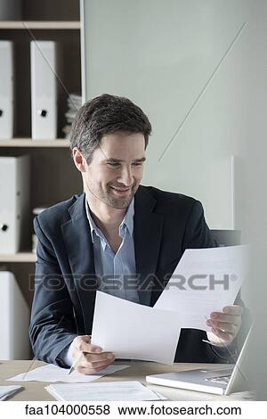 Businessman reviewing paperwork View Large Photo Image Stock Photo - Businessman reviewing paperwork. Fotosearch