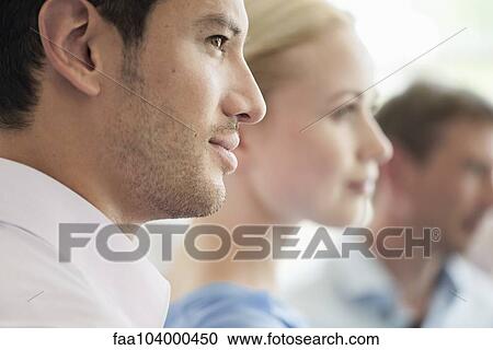 Stock Image - Businessman with colleagues at meeting. Fotosearch
