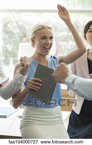 Stock Photo - Businesswoman celebrating success with colleagues. Fotosearch