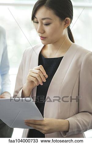 Businesswoman reviewing document with colleague View Large Photo Image Stock Image - Businesswoman reviewing document with colleague. Fotosearch