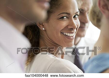 Stock Photo - Businesswoman smiling over shoulder, portrait. Fotosearch