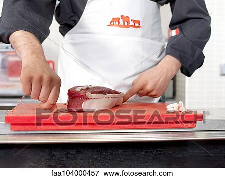Stock Photo - Butcher tying twine around meat cut. Fotosearch
