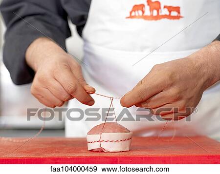 Butcher tying twine around meat cut, cropped View Large Photo Image Stock Photo - Butcher tying twine around meat cut, cropped. Fotosearch