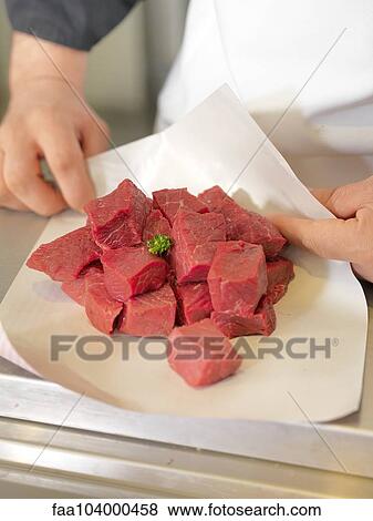 Butcher wrapping meat cubes in wax paper, cropped View Large Photo Image Stock Photo - Butcher wrapping meat cubes in wax paper, cropped. Fotosearch