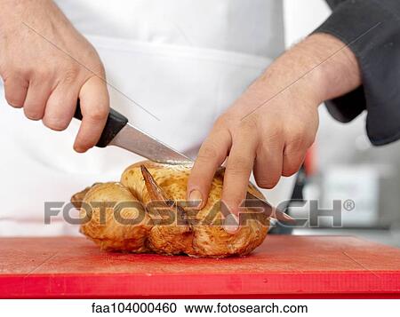 Stock Image - Chef cutting roasted chicken. Fotosearch