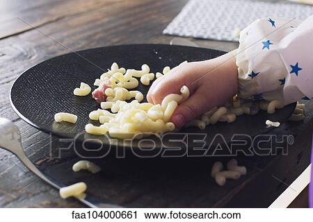 Child eating macaroni with her hand, cropped View Large Photo Image Stock Image - Child eating macaroni with her hand, cropped. Fotosearch