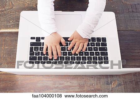 Stock Photo - Child's hands on laptop computer keyboard. Fotosearch