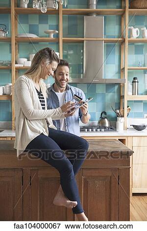 Stock Photo - Couple shopping online at home. Fotosearch