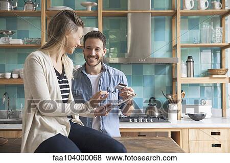 Couple using digital tablet in kitchen View Large Photo Image Stock Photo - Couple using digital tablet in kitchen. Fotosearch