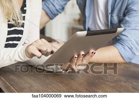Couple using digital tablet together View Large Photo Image Stock Photo - Couple using digital tablet together. Fotosearch