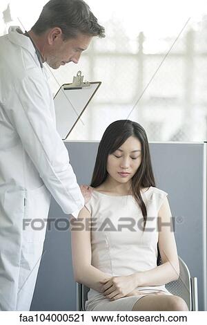 Stock Image - Doctor comforting patient in waiting room. Fotosearch