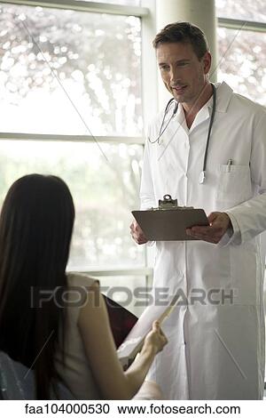 Doctor greeting patient in waiting room View Large Photo Image Stock Image - Doctor greeting patient in waiting room. Fotosearch
