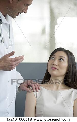 Doctor speaking to patient in waiting room View Large Photo Image Stock Photo - Doctor speaking to patient in waiting room. Fotosearch