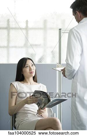 Doctor speaking to patient in waiting room View Large Photo Image Stock Photography - Doctor speaking to patient in waiting room. Fotosearch