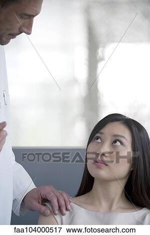 Doctor speaking with concerned patient View Large Photo Image Stock Photo - Doctor speaking with concerned patient. Fotosearch