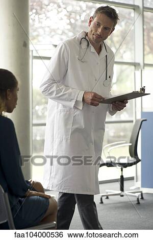 Doctor talking with patient in waiting room View Large Photo Image Stock Photograph - Doctor talking with patient in waiting room. Fotosearch