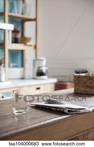 Empty wine glass and newspaper left on kitchen counter View Large Photo Image Stock Image - Empty wine glass and newspaper left on kitchen counter. Fotosearch