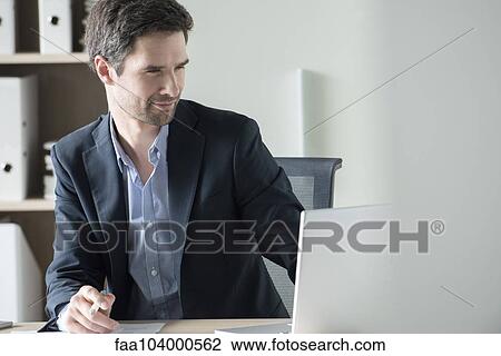 Stock Image - Entrepreneur using laptop. Fotosearch