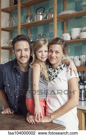 Stock Image - Family at home together in kitchen, portrait. Fotosearch