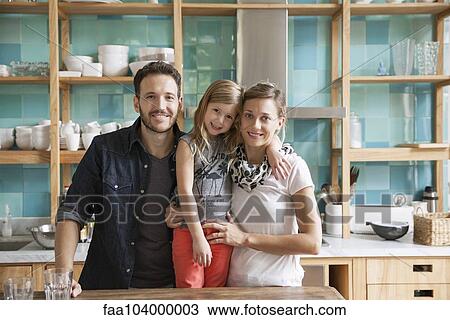 Stock Image - Family at home together in kitchen, portrait. Fotosearch
