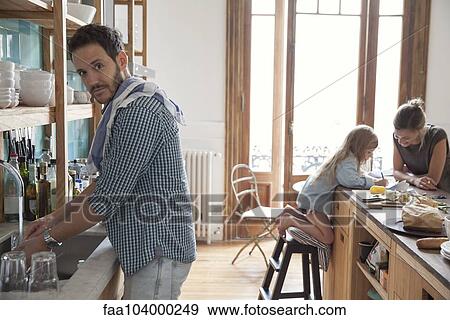 Family in kitchen, man doing dishes in foreground View Large Photo Image Stock Photo - Family in kitchen, man doing dishes in foreground. Fotosearch