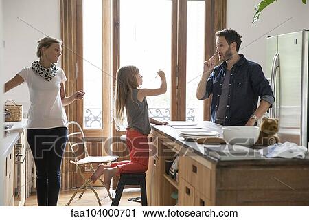 Stock Image - Family together at home in kitchen. Fotosearch