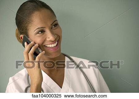 Female nurse talking on cell phone and smiling cheerfully View Large Photo Image Stock Photography - Female nurse talking on cell phone and smiling cheerfully. Fotosearch