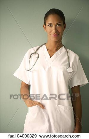Stock Photo - Female nurse with hand in pocket, smiling, portrait. Fotosearch