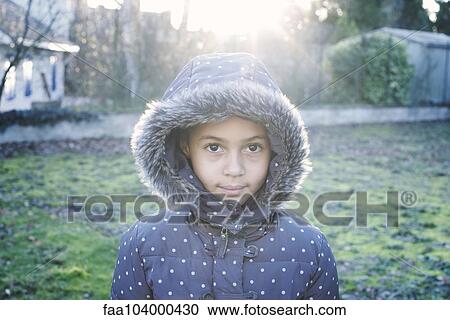 Stock Image - Girl wearing hooded coat, portrait. Fotosearch