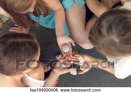 Stock Photo - Girls studying rocks together, overhead view. Fotosearch