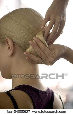 Hairdresser arranging woman's hair in a chignon, cropped View Large Photo Image Stock Photo - Hairdresser arranging woman's hair in a chignon, cropped. Fotosearch