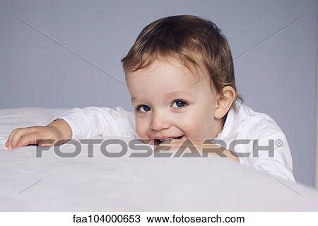 Little boy resting head on bed, portrait View Large Photo Image Stock Image - Little boy resting head on bed, portrait. Fotosearch
