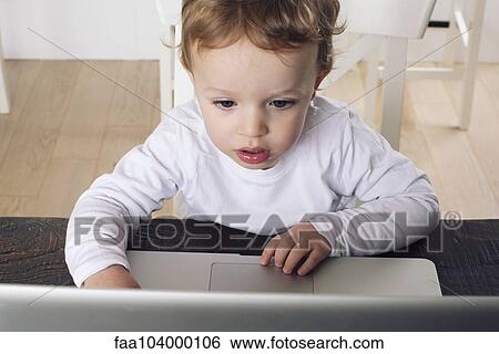 Stock Photograph - Little boy using laptop computer. Fotosearch