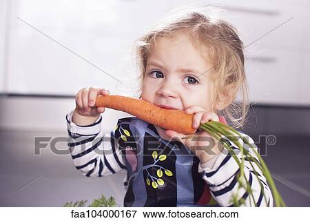 Little girl eating a carrot View Large Photo Image Stock Photo - Little girl eating a carrot. Fotosearch