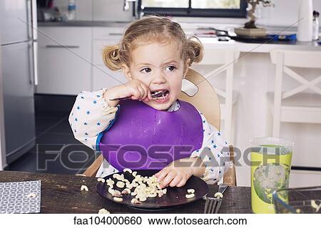 Stock Image - Little girl eating lunch. Fotosearch
