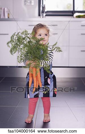 Picture - Little girl holding fresh carrots. Fotosearch