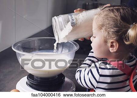 Stock Photograph - Little girl pouring flour into mixing bowl. Fotosearch